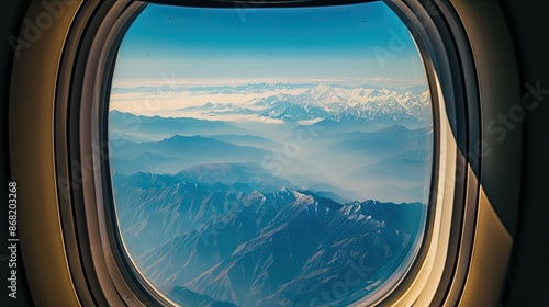 View from airplane window showing dramatic mountain ranges during a flight © chanidapa