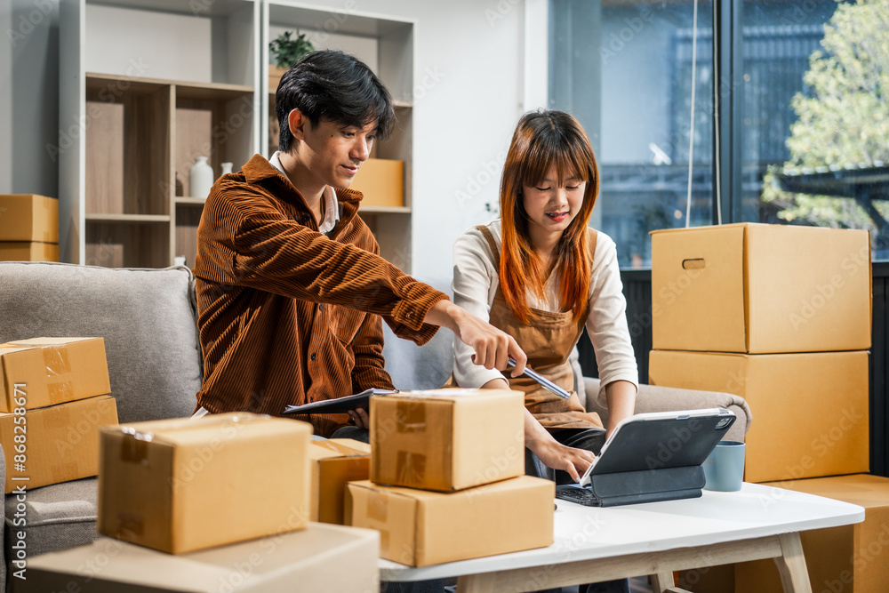 A young couple works from home, packing orders and managing their online store. They use technology and teamwork to run their business, smiling while fulfilling customer orders. A young couple works from home, packing orders and managing their online store. They use technology and teamwork to run their business, smiling while fulfilling customer orders.