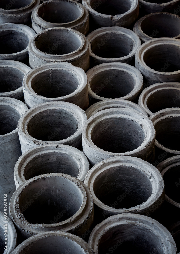 A stack of concrete ring pipes piled and creating a symmetrical arrangement A stack of concrete ring pipes piled and creating a symmetrical arrangement