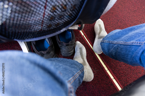 Seated aIrplane passenger removed shoes in cabin to relax feet during long haul flight