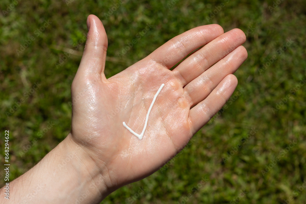 A person applying the correct amount of sunscreen for face and neck - tick.