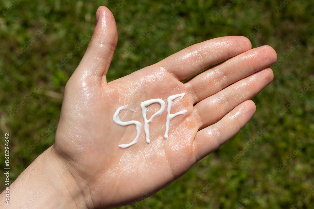 A person applying the correct amount of sunscreen for face and neck.