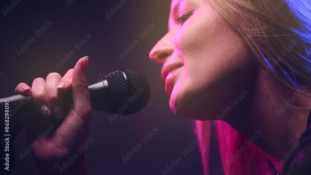 Singing Woman with Microphone. Karaoke bar. Beauty Glamour Singer Girl close-up. Stage. Rock star singer on music concert over colorful lights background. Song. Pop music Singing Woman with Microphone. Karaoke bar. Beauty Glamour Singer Girl close-up. Stage. Rock star singer on music concert over colorful lights background. Song. Pop music