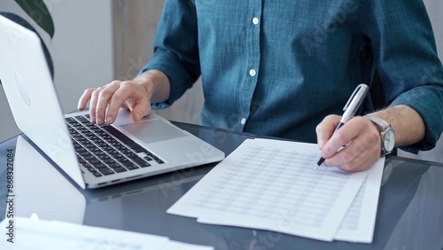 Canvas Print Businessman or professional auditor is analyzing data on laptop