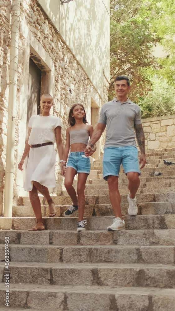 The family is traveling, walking in a beautiful old town, dad and daughter holding hands The family is traveling, walking in a beautiful old town, dad and daughter holding hands