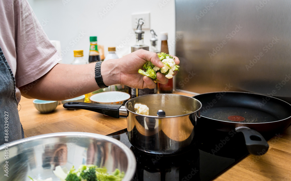 Chef at the kitchen preparing lentils soup with cauliflower and broccoli Chef at the kitchen preparing lentils soup with cauliflower and broccoli