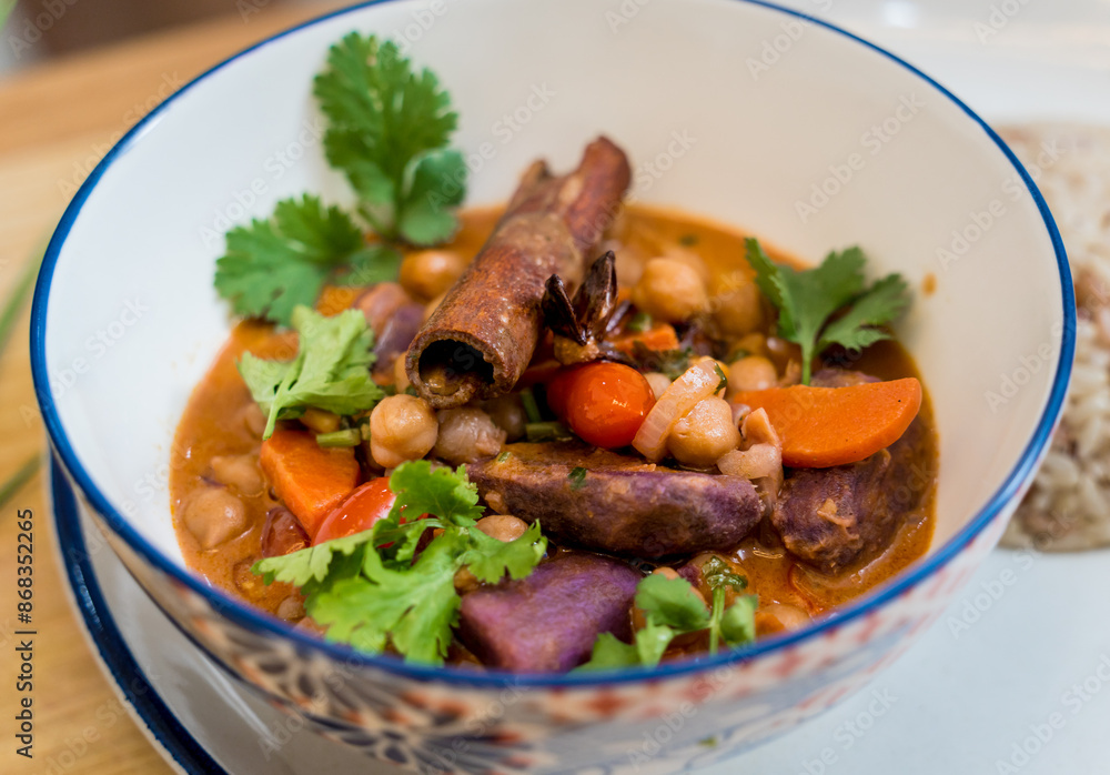 A vegetarian massaman curry in a bowl with sweet potato and many spices A vegetarian massaman curry in a bowl with sweet potato and many spices