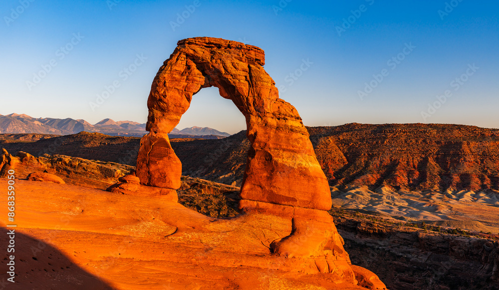 Delicate Arch - The most famous landmark of the Arches National Park in Utah in strong sunlight during sunset.