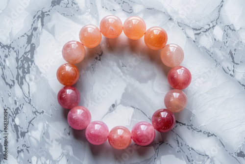 pink and orange jade bracelet on a white marble surface, summer accessories