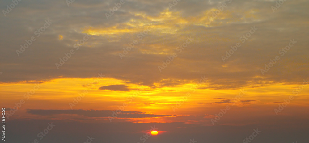 The morning sky looked like a bright golden sky. The sunrise is decorated with clouds in various shapes. Wide photo. The morning sky looked like a bright golden sky. The sunrise is decorated with clouds in various shapes. Wide photo.