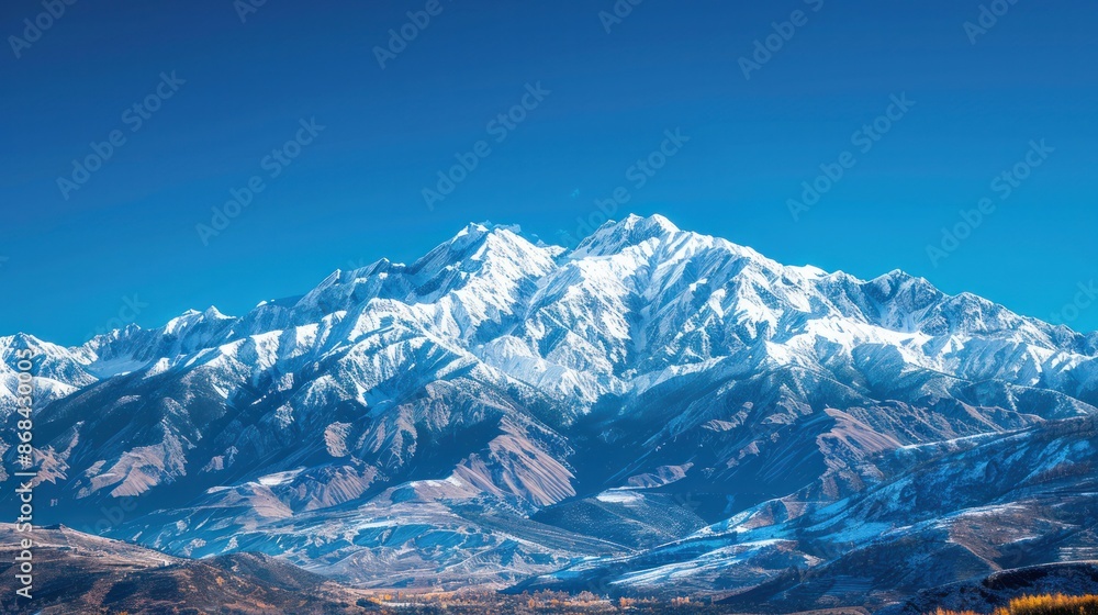 Fototapeta premium A snow-covered mountain range under a clear blue sky, capturing the majesty of nature