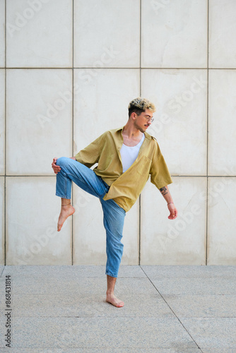 Foto Young man barefoot, with dyed hair is dancing contemporary dance