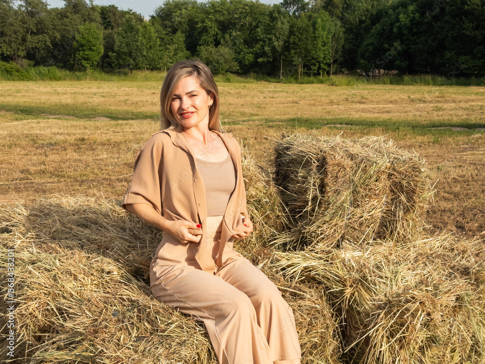 Attractive, sexy blonde in a beige near a haystack Attractive, sexy blonde in a beige near a haystack