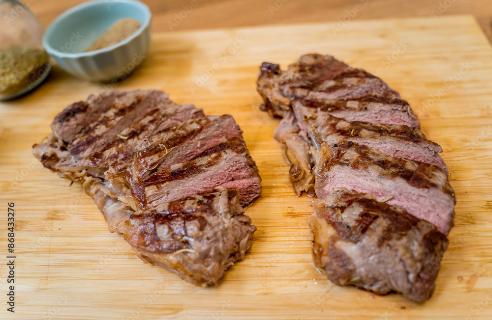 Chef at the kitchen preparing beef steaks on the home electric grill Chef at the kitchen preparing beef steaks on the home electric grill