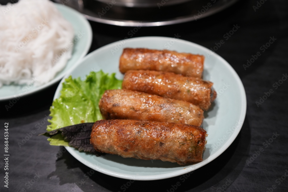 Deep fried Spring Rolls with green vegetable on banana leaf and white plate - 春巻き
Deep fried Spring Rolls with green vegetable on banana leaf and white plate - 春巻き