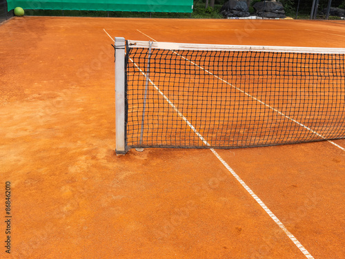 Tennis net on the court background.Empty tennis court in the park on sunny day. 