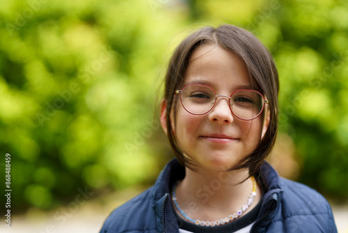 Konstfotografi Little cheerful teenage girl wearing glasses outdoors