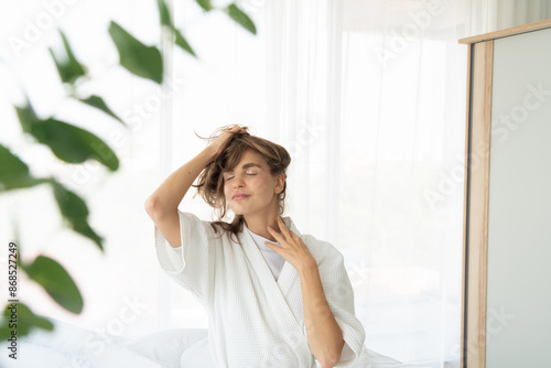 woman checks her hair health after waking up in the morning.