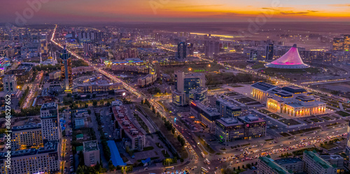 The night aerial view of Astana downtown (the Republic of Kazakhstan), with Khan Shatyr shopping mall, Astana opera house, Kabanbay Batyr avenue, the beautiful city lights and scenic sky.
 photo