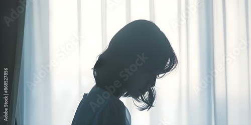 Young Asian woman silhouette upset and crying alone in room. Concept Depression, Loneliness, Sadness, Emotional Distress, Young Woman