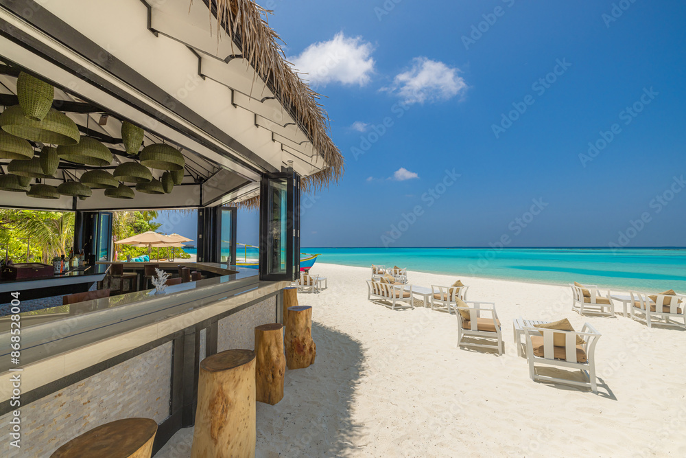 Obraz premium Outdoors beach bar with clear blue sea sky. Relaxing beachfront bar with chairs sun umbrellas. Luxury summer travel background. Freedom tropical sunny coast, summertime vibes pattern. Exotic tourism