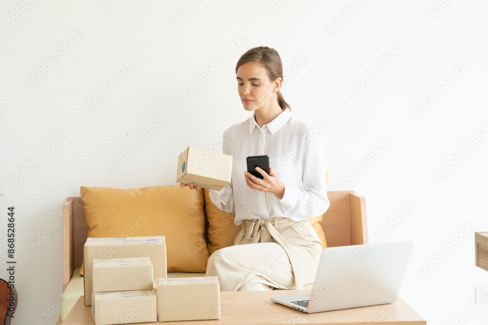 Woman packing to deliver parcels to customers who order in an online store. Check and confirm orders with customers Woman packing to deliver parcels to customers who order in an online store. Check and confirm orders with customers