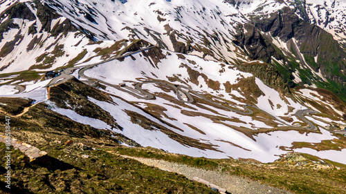 Alpenabhang mit Schnee bedeckt und Straße im Vordergrund