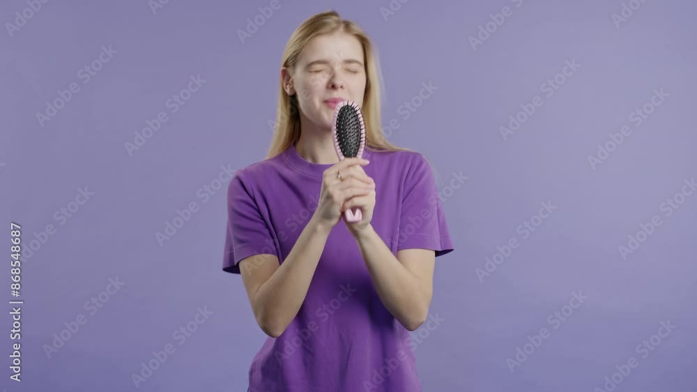 Woman singing, dancing with hair brush instead microphone on Violet background Woman singing, dancing with hair brush instead microphone on Violet background
