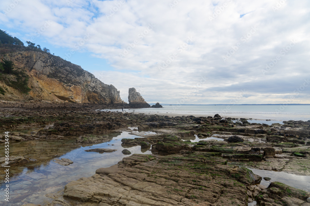 Fototapeta premium Falaise et formation rocheuse sur une plage de la presqu'île de Crozon à marée basse, en Bretagne.