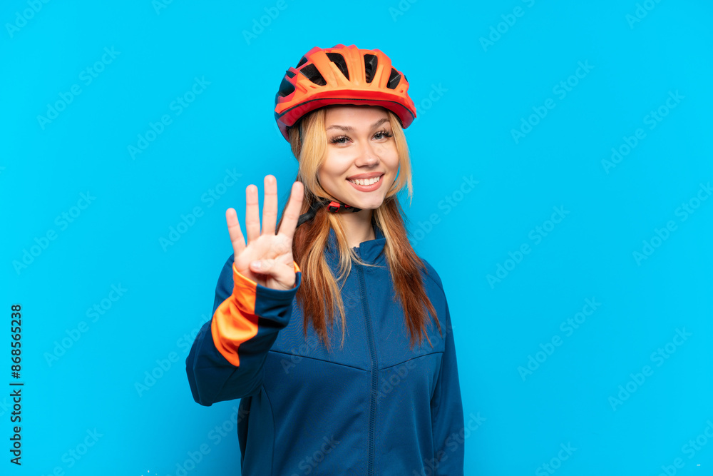 Young cyclist girl isolated on blue background happy and counting four with fingers Young cyclist girl isolated on blue background happy and counting four with fingers