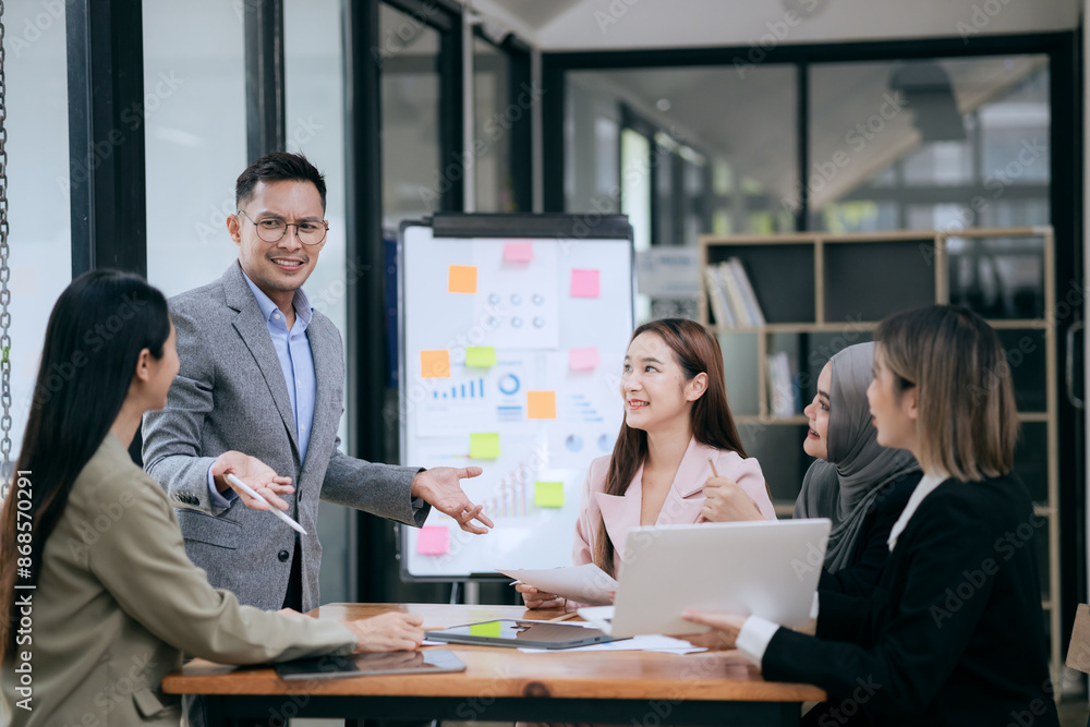 Fototapeta premium Professional team at and both male and female members participated in a lively brainstorming session at the company office. They collaborate on creative projects using modern technology.