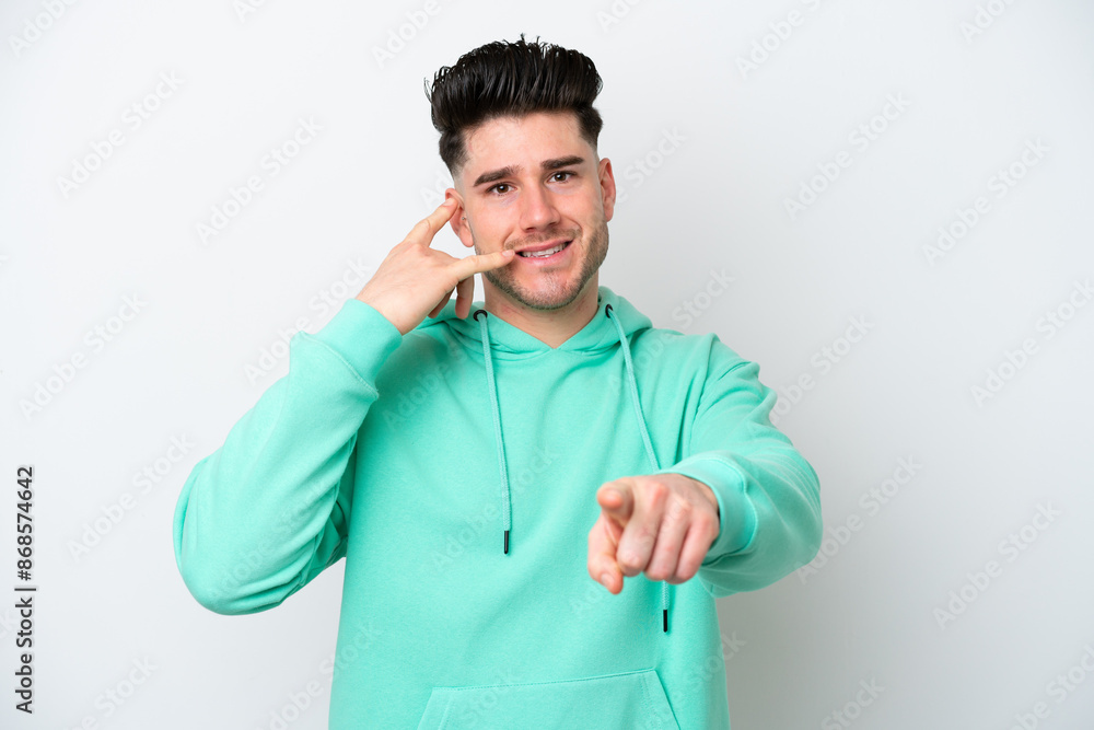 Young caucasian man isolated on white background making phone gesture and pointing front Young caucasian man isolated on white background making phone gesture and pointing front
