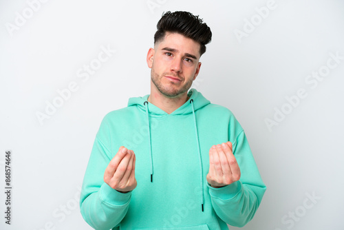 Young caucasian man isolated on white background making money gesture but is ruined © luismolinero