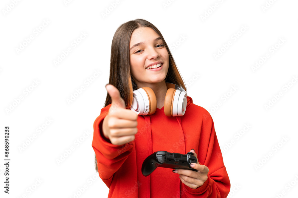 Teenager caucasian girl playing with a video game controller over isolated background with thumbs up because something good has happened Teenager caucasian girl playing with a video game controller over isolated background with thumbs up because something good has happened
