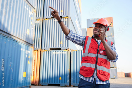 African factory worker or engineer using walkie talkie and talking about work in containers warehouse storage