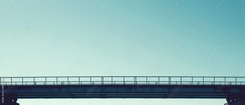 Fototapeta premium A bridge with a railing and a blue sky in the background