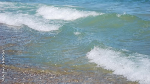 Waves gently rolling onto the sandy beach in slow motion in slow motion 300fps photo