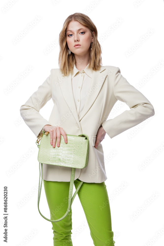 High fashion photo of a beautiful elegant young woman in pretty green pants, trousers, jacket, handbag posing on white background. Slim figure. Blonde High fashion photo of a beautiful elegant young woman in pretty green pants, trousers, jacket, handbag posing on white background. Slim figure. Blonde