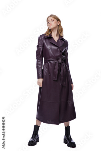 High fashion photo of a beautiful elegant young woman in pretty long purple lilac leather jacket, coat posing on white background. Slim figure. Blonde