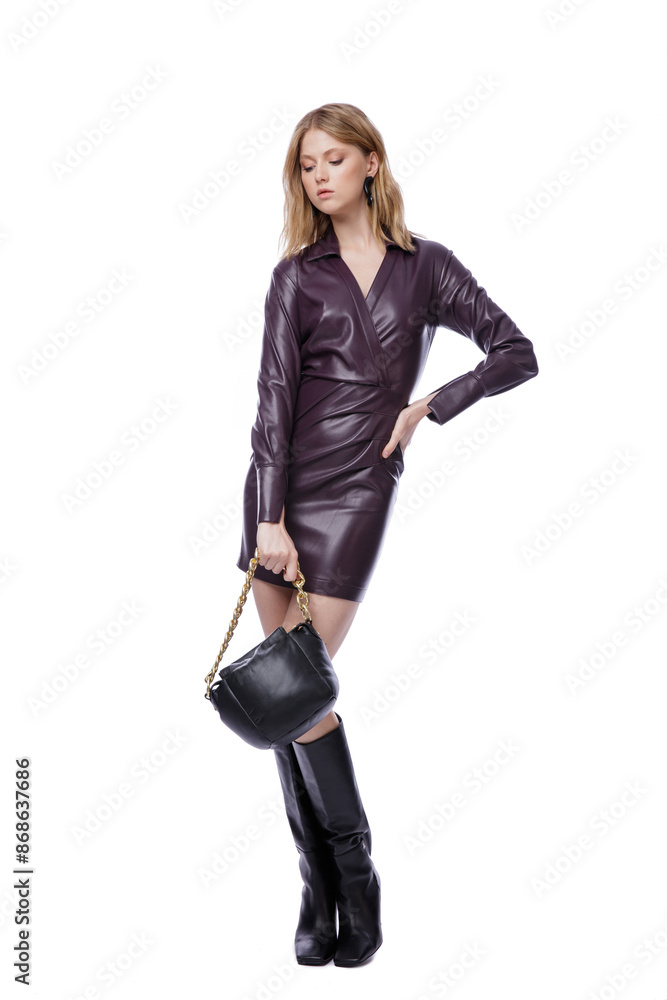 High fashion photo of a beautiful elegant young woman in pretty short purple lilac leather dress with sleeves, black high boots, jackboot, handbag posing on white background. Slim figure. Blonde High fashion photo of a beautiful elegant young woman in pretty short purple lilac leather dress with sleeves, black high boots, jackboot, handbag posing on white background. Slim figure. Blonde