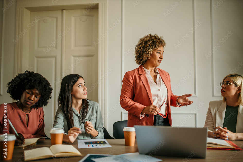 Happy group of business people discussing strategy during a team meeting at the office desk together Happy group of business people discussing strategy during a team meeting at the office desk together