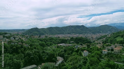 aerial view with fly up revealing effect of Spina verde mountains that around the Como city with Baradello tower in evidence photo