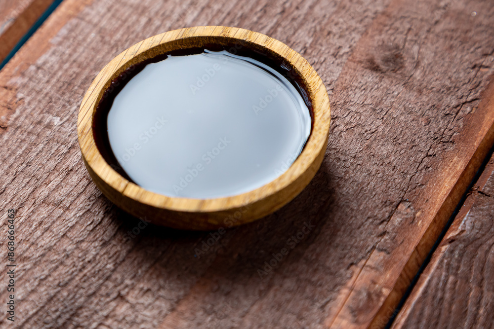 soy sauce in a wooden plate on a board on the table soy sauce in a wooden plate on a board on the table