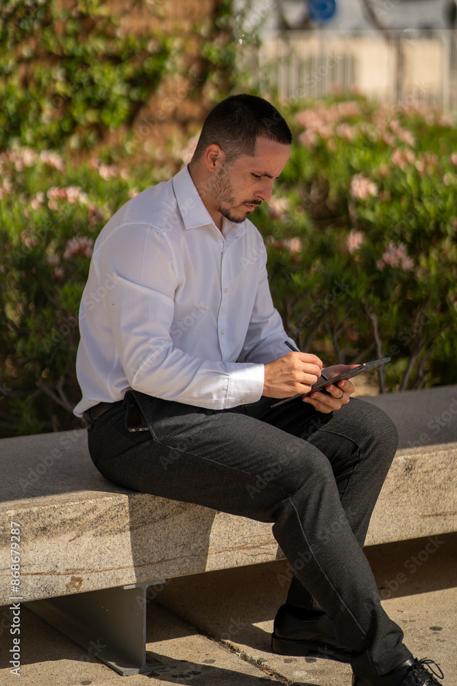 Hombre joven con traje y camisa en sitio lujoso con mar. Business man. Trabajando con tablet y móvil. Hombre joven con traje y camisa en sitio lujoso con mar. Business man. Trabajando con tablet y móvil.
