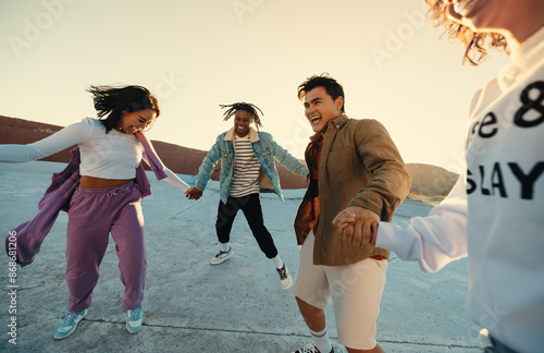 Photography Friends dancing and having fun outdoors at sunset in a candid, joyful moment