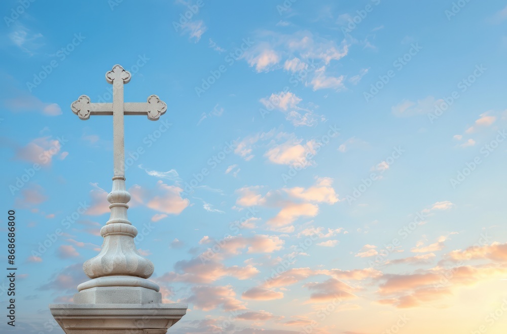 A white cross stands tall against a backdrop of a vibrant blue sky and soft clouds. A white cross stands tall against a backdrop of a vibrant blue sky and soft clouds.