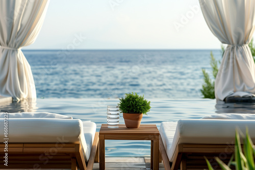 Beach beds with towels on them in front of the ocean at sunset