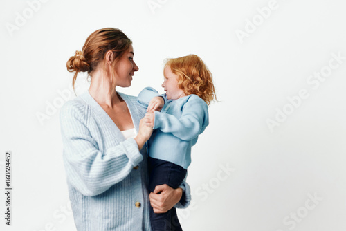 Mother and daughter embracing in front of blank white background, family love and beauty concept