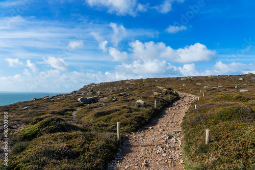 Le sentier côtier de la presqu'île de Crozon longe la mer d'Iroise en Bretagne, traversant une lande de bruyère et d'ajoncs, offrant des panoramas spectaculaires. photo