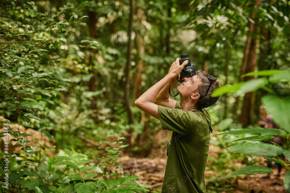 Camera, photographer and man in tropical jungle for vacation, travel and trekking on holiday. Technology, photography and person in rainforest for picture, tourism and hiking on adventure outdoor Camera, photographer and man in tropical jungle for vacation, travel and trekking on holiday. Technology, photography and person in rainforest for picture, tourism and hiking on adventure outdoor